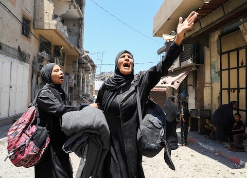 A Palestinian woman reacts in the aftermath of an Israeli strike on a house, in Gaza City